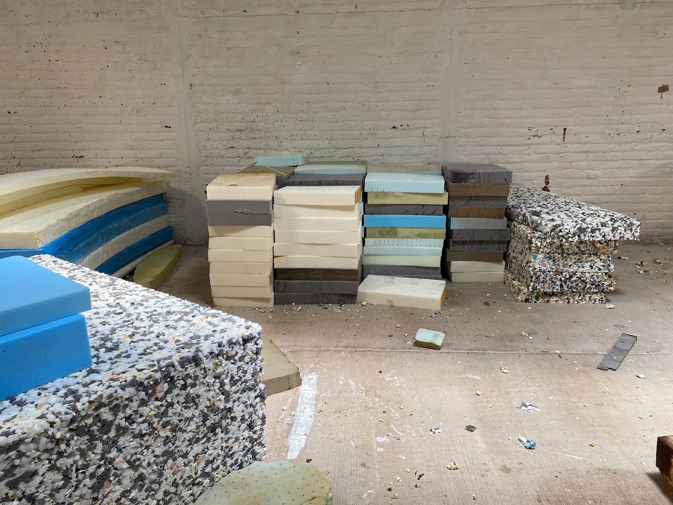 Láminas de esponja de varias densidades y colores apiladas en la planta de Guma